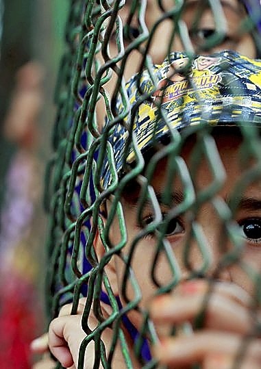 Un niño mira a través de una verja en la región.