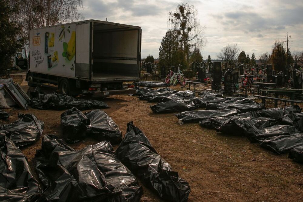 Un grupo de agentes y operarios del cementerio de Bucha identifican los cuerpos de decenas de víctimas.