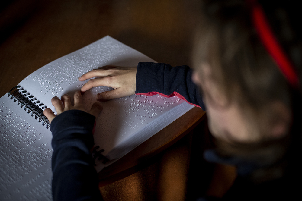 Cristina estudia equitación con su libro en braille