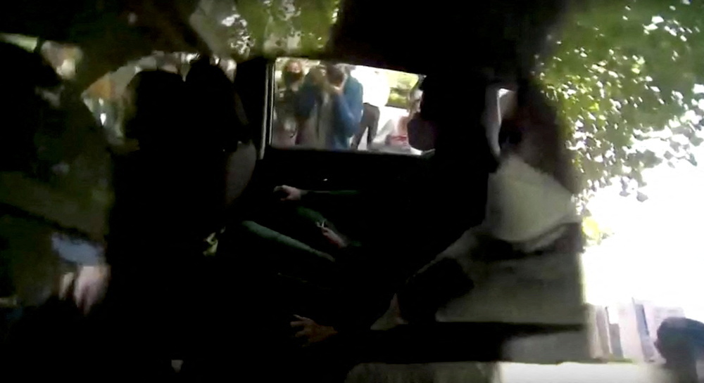 Djokovic, sentado al fondo del vehículo, llega en coche al hotel donde permanecerá detenido hasta la nueva vista judicial.