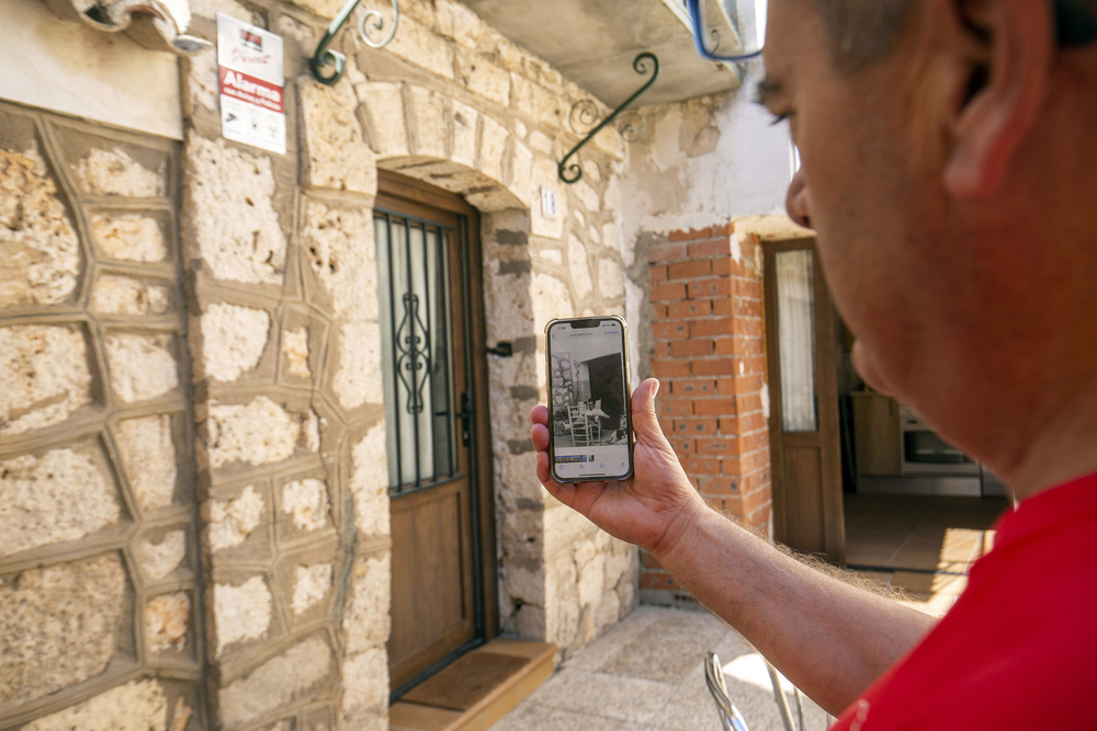 En el teléfono móvil se puede apreciar una fotografía de época en la que se ve a Manuel Rodríguez frente a la fachada principal de su casa en Fuentelencina.